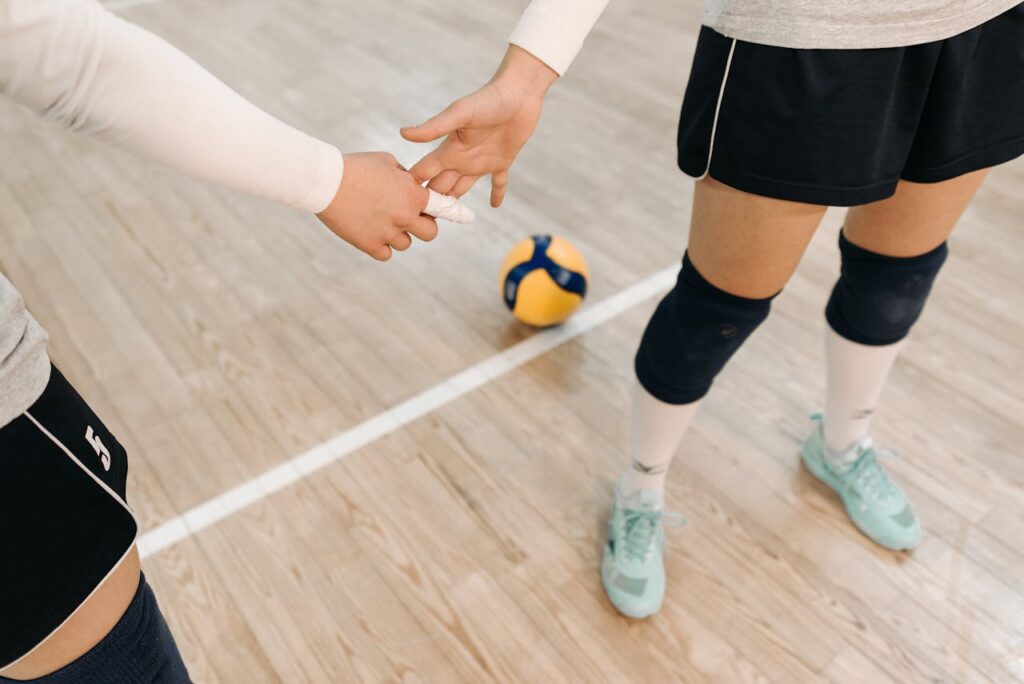 Close-up of volleyball players with hands in unity, ready for game action.